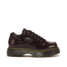 Load image into Gallery viewer, A single Dr. Martens low-top platform sneaker in glossy dark burgundy patent leather with a crocodile-embossed texture, black laces, and a signature yellow welt stitch on a black platform sole, shown against a plain white background.