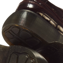 Load image into Gallery viewer, Close-up of the sole and heel of a dark brown glossy crocodile-embossed shoe, showing the textured black rubber tread and heel counter against a light gray background.