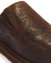 Load image into Gallery viewer, Close-up of a dark brown leather boot featuring an embossed floral and leaf pattern on the upper, with a matching stitched pull tab and a ribbed sole edge, set against a clean white background.