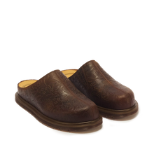 Load image into Gallery viewer, A pair of dark brown leather slip-on clogs with an embossed floral pattern, shown from a three-quarters angle on a white background.