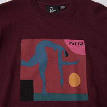 Load image into Gallery viewer, A close-up of a maroon crewneck sweatshirt featuring a colorful graphic print on the front. The graphic depicts a blue stylized figure in a square frame with pink, yellow, and teal shapes, and the word 'pàrrà' written in black.